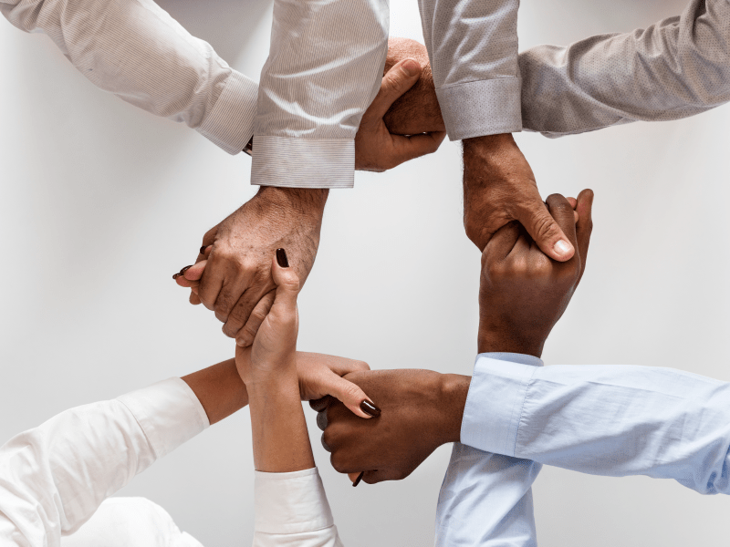 people holding hands representing teamwork